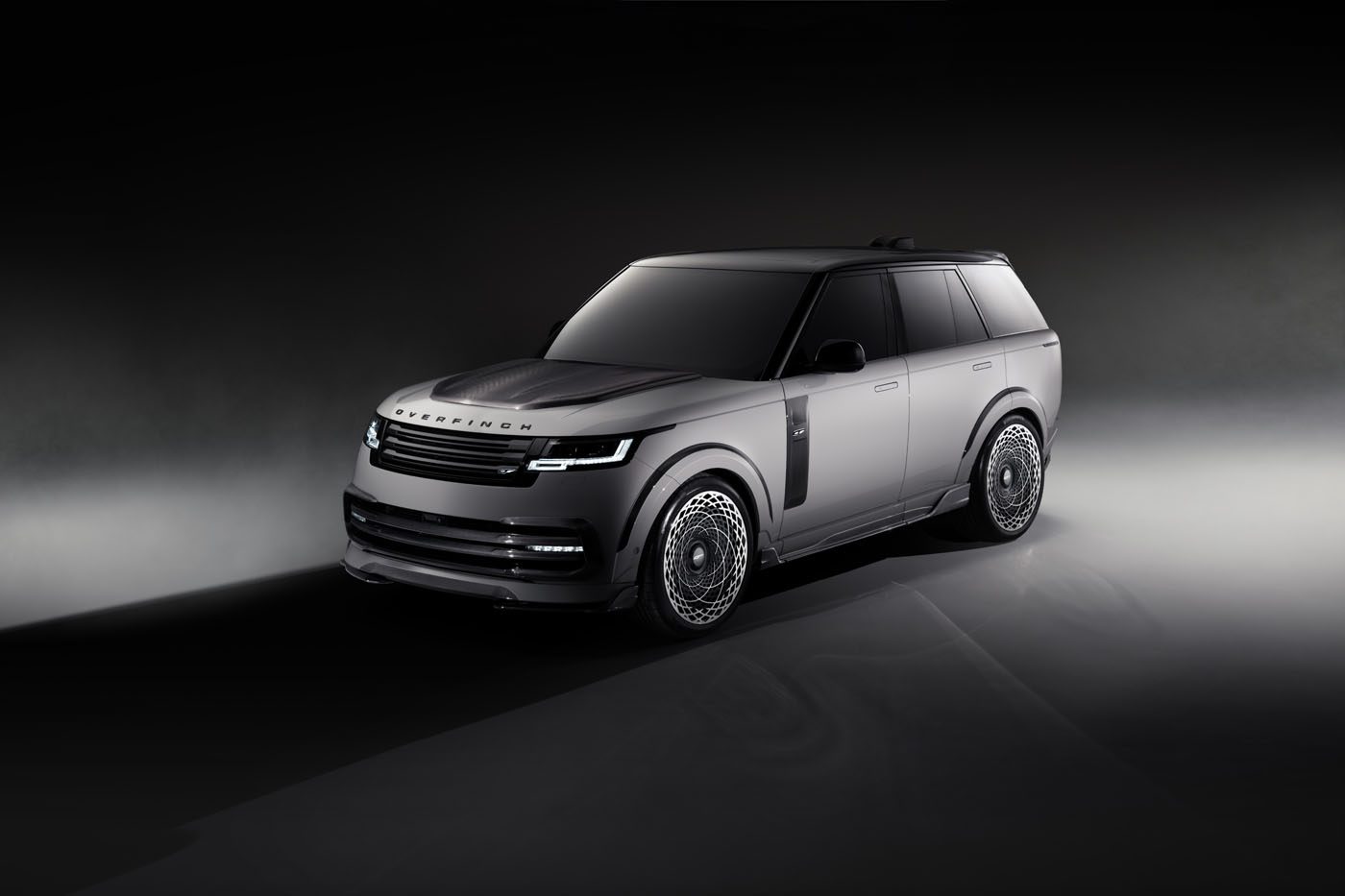 A sleek, matte black SUV, boasting the powerful aesthetic of the Overfinch Velocity Edition, features reflective windows and intricate wheel designs against a dark gradient background.