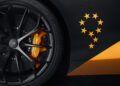 A close-up of a McLaren wheel with a vibrant yellow brake caliper labeled "750S;" the adjacent panel showcases an intricate design of yellow stars arranged in a circular pattern.