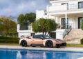 A luxury Maserati GT2 Stradale is elegantly parked by a shimmering swimming pool in front of a grand white villa, set amidst lush greenery. This stunning scene captures the essence of opulence and adventure, reminiscent of a sun-drenched escape in Spain.