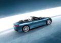 The Maserati GranCabrio, a sleek blue convertible sports car, is elegantly parked on a reflective surface. From the side and rear, it captures attention with a bright horizontal light in the background, evoking the thrilling ambiance of I.C.E. St. Moritz.