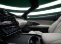 The interior of a Maserati GranCabrio showcases a digital dashboard display with vehicle settings, a sleek design, and luxurious beige leather seats. With its impressive 483HP under the hood, it's the epitome of style and performance on any I.C.E. St. Moritz road trip.