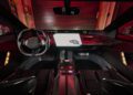 Futuristic car interior featuring a central touchscreen, steering wheel, digital display, and red ambient lighting. In this BMW Vision-inspired design, two seats reflect a sleek modern aesthetic with cutting-edge EV Tech integration.