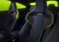 The interior of a car with black and yellow sport seats, showcasing the "VR-46" logo in honor of Valentino Rossi's iconic energy, set against a vibrant green background.
