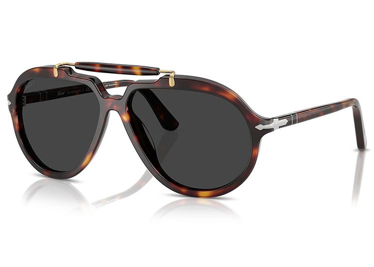 Embodying the essence of luxury sunglasses, these tortoiseshell shades boast dark lenses and a sleek metal bridge with silver accents adorning the arms, elegantly displayed on a glossy white surface.