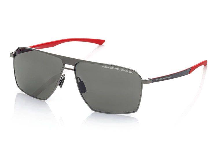 Experience the ultimate driver accessory with Porsche Design luxury sunglasses, featuring dark lenses, a sleek metallic frame, and striking red temple tips.
