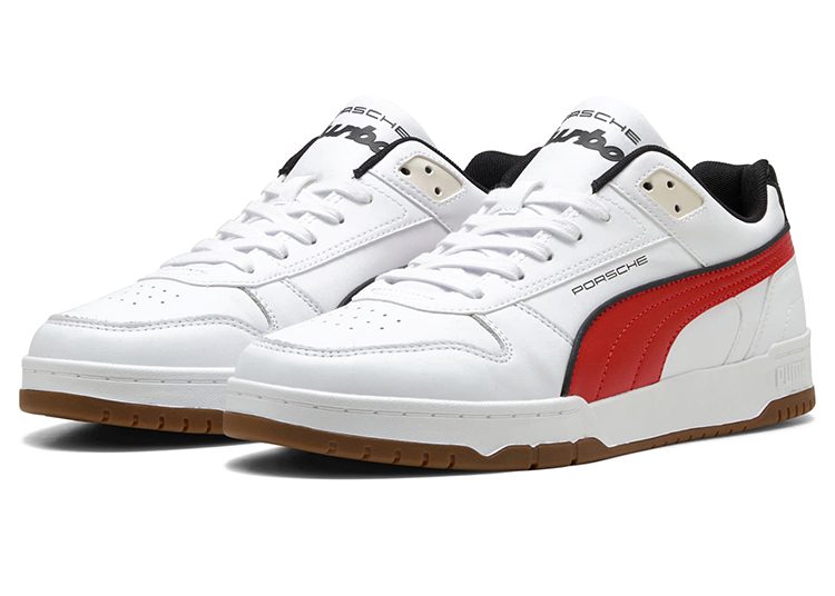 A pair of white PUMA sneakers with red and black accents, brown rubber soles, and "Porsche" branding on the side and tongue—perfect for the automotive-inspired driver.