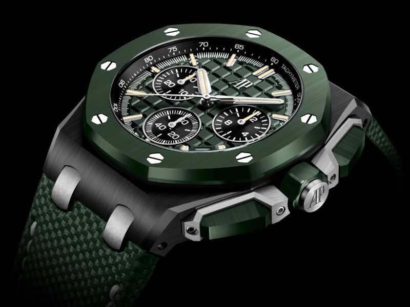 Green wristwatch with a hexagonal bezel, silver screws, and three sub-dials set on a textured strap. This Audemars Piguet masterpiece features the initials "AP" on the crown, celebrating their 150th anniversary with this elegant design.