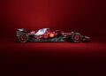 A Ferrari SF-25, boasting its iconic black and red livery adorned with sponsor logos, stands prominently against a solid red background.