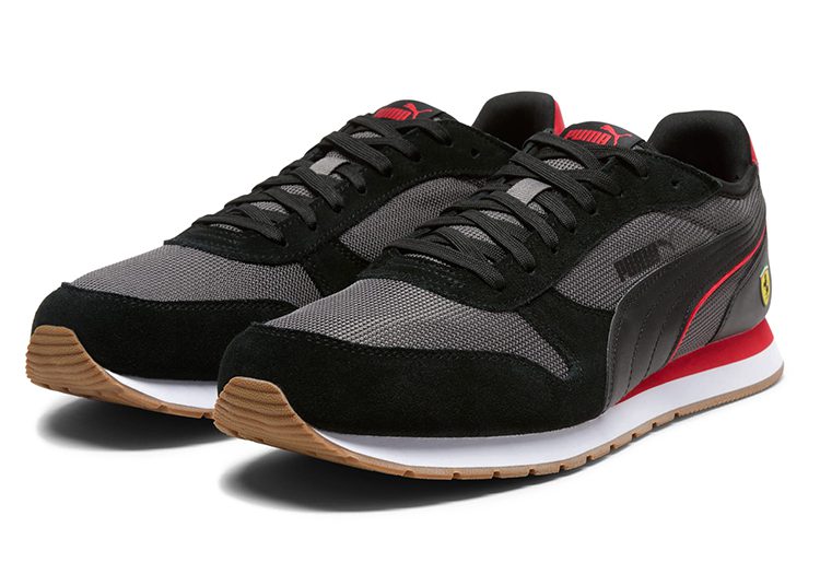 A pair of black, gray, and red PUMA sneakers with white midsoles and gum rubber outsoles, displayed on a white background—these automotive-inspired kicks are perfect for the ultimate driver.