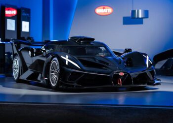 At Miller Motorcars, a sleek black hypercar is showcased indoors under blue lighting, flaunting aerodynamic design features and a prominent rear wing.
