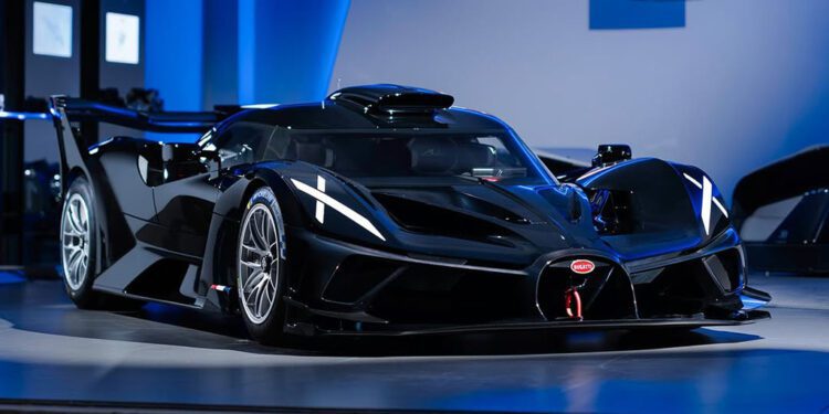 At Miller Motorcars, a sleek black hypercar is showcased indoors under blue lighting, flaunting aerodynamic design features and a prominent rear wing.