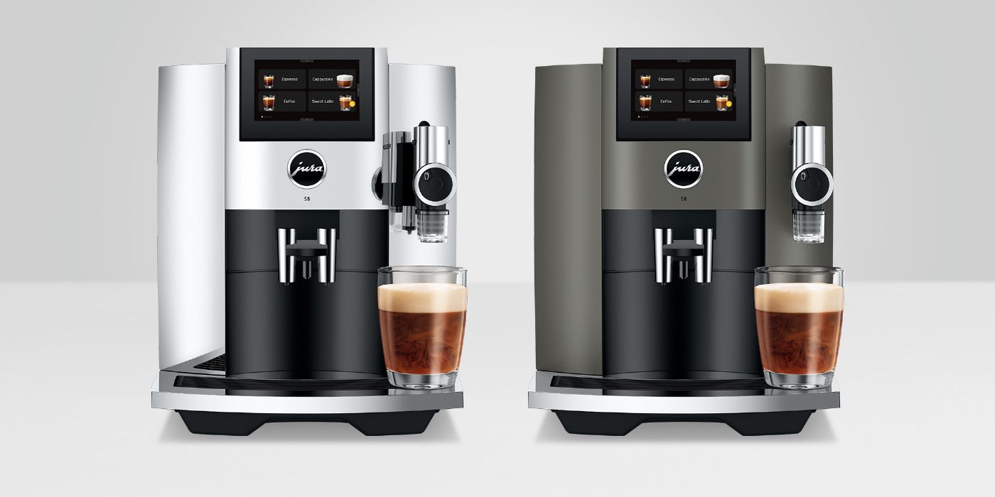 Two modern coffee machines, one silver and one black, each boast digital screens and a glass of coffee placed in front, exemplifying JURA S8's innovation in coffee enjoyment on a neutral background.
