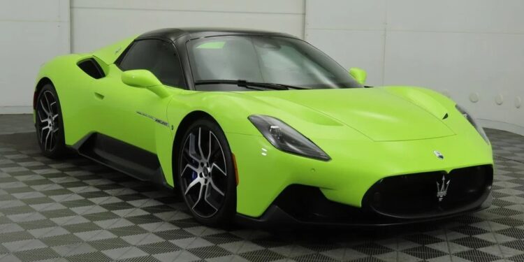 A bright green Maserati MC20 sports car, one of the best green supercars, is parked in a showroom with gray checkered flooring and white walls.