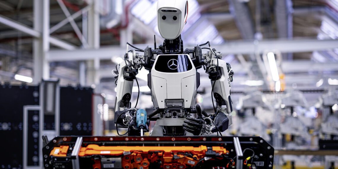 In a bustling factory, a humanoid robot equipped with AI meticulously works on an industrial vehicle component, seamlessly integrating innovation into the assembly line. The efficiency and precision echo the standards of Mercedes-Benz, surrounded by state-of-the-art machinery and equipment.
