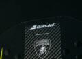 Close-up of a BL002 Carbon Padel Racquet by Babolat, showcasing its sleek carbon fiber design with striking yellow accents and the prestigious Automobili Lamborghini logo.