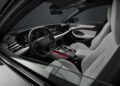 Interior view of a modern Audi A6 Avant Wagon featuring a digital dashboard, steering wheel, and light gray leather seats, with ambient lighting accents that enhance its hybrid sophistication.