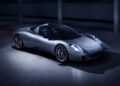 A sleek, silver sports car is parked indoors, illuminated by overhead lighting. The car boasts a modern, aerodynamic design with smooth curves and visible headlights—a true marvel of automotive design that echoes the brilliance seen at Goodwood events.