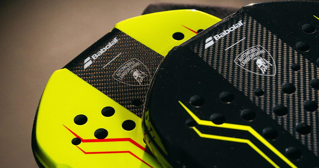 Close-up of two Babolat padel rackets, one yellow and one black, featuring the BL002 Carbon Padel Racquet design with Lamborghini branding and carbon fiber texture.