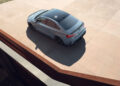 A blue Audi sedan, possibly the RS 3 with its robust 5-cylinder engine, is parked on a concrete surface and viewed from an elevated angle.
