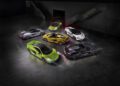 Five luxury sports cars, including a striking green McLaren, gleam under dim lighting. Showcased in an exclusive indoor setting, these vehicles set the stage for an unforgettable Owner Events experience.