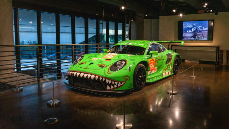 Mobil balap hijau yang semarak dengan desain wajah tersenyum bersinar di ruang pamer di Porsche Experience Center, Atlanta. Lineup ultra-eksklusif ini menawarkan latar belakang layar ramping dan jendela yang luas, meningkatkan daya pikatnya.