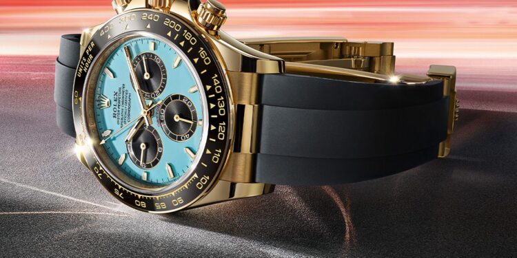 A gold and black Rolex wristwatch with a blue face and gold markings is displayed against a dynamic, blurred background, capturing the essence of 2025 Watches.