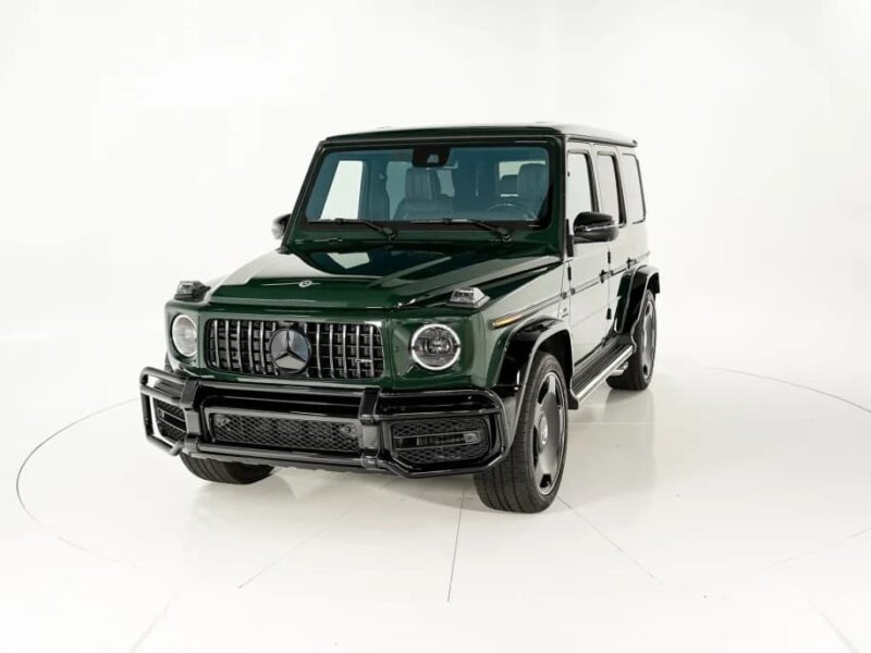 A dark green Mercedes-Benz G-Class SUV, one of the best green supercars, is parked in a white studio setting, viewed from the front left angle.