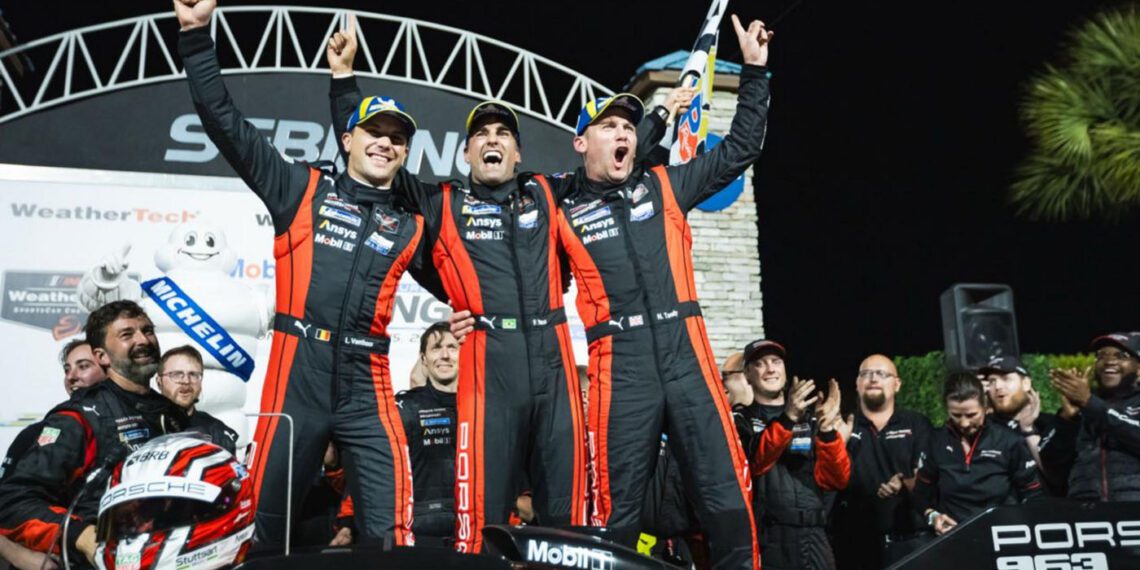 Three race car drivers in matching suits celebrate their Porsche victory on the podium, arms raised high. The iconic race car and cheering team members form a jubilant backdrop after the intense 12 Hours of Sebring spectacle.