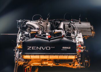 A high-performance Mahle Powertrain V12 engine, labeled "Zenvo V12-4T," with visible components shines against a gradient background, embodying the essence of a powerful road car.