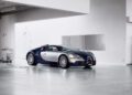 A blue and silver Bugatti sports car, powered by the iconic W16 engine, is parked in a minimal, modern garage with white walls and polished concrete floors.