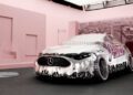 A shiny, metallic Mercedes-Benz CLA concept car with a melting appearance is displayed in a pink room with cityscape wallpaper, creating an Ice Spice remix of futuristic style and urban vibes.
