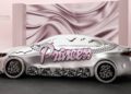 A silver Mercedes-Benz CLA with decorative elements, including the word "Princess" in large, pink script, ornate wheel covers, and metallic accents, is parked remix-style in front of a pink satin backdrop.