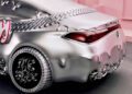 A silver Mercedes-Benz CLA with a melted, futuristic design is parked indoors against a pink wall, giving off serious Remix vibes.