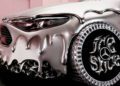 A silver Mercedes-Benz CLA with a melting, liquid metal effect on its body and large, ornate wheels featuring the Mercedes logo in a stylized font—it's a true remix of style and innovation.