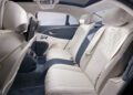 The luxurious interior of the Bentley Continental boasts two cream-colored leather seats, digital screens, and elegant design details, reflecting its powerful 671HP capability.
