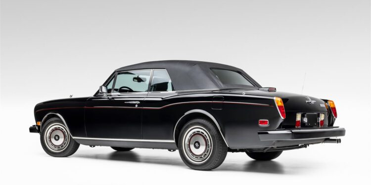 A classic black Rolls-Royce convertible with the top up, viewed from the rear side angle against a plain white background, reminiscent of elegance and luxury fit for a Wayne Gretzky auction at RM Sotheby's.