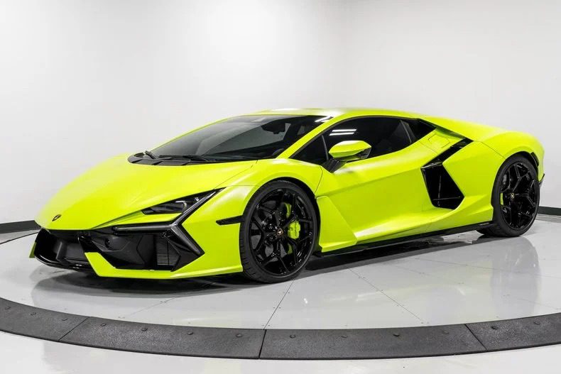 A bright yellow-green Lamborghini Revuelto supercar is parked in a clean indoor showroom with a white background and glossy floor.