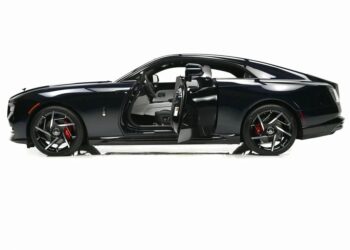 Side view of an ultra-luxury black Rolls-Royce Spectre electric super coupe with its driver’s side door open, showcasing black wheels with red brake calipers and a light-colored interior.