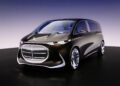 A sleek black Mercedes-Benz concept minivan with a futuristic design, large illuminated front grille, and smooth, reflective surfaces displayed on a showroom floor exudes ultra-luxury sophistication.