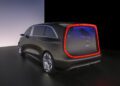 A futuristic black Mercedes-Benz Vision V concept van with illuminated red trim around the rear and large silver wheels, this ultra-luxury Sprinter Van is displayed in a minimalistic indoor setting.