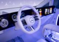 Futuristic Mercedes-Benz Sprinter Van interior with a digital dashboard, illuminated controls, a white steering wheel, and ambient blue lighting for an ultra-luxury driving experience.