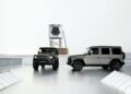 Two Mercedes-Benz off-road vehicles on a rooftop with a water tower in the background featuring Moncler's logo, blending rugged elegance with high fashion.