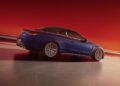 A limited-edition blue convertible sports car with a black roof speeds along the track, its sleek design highlighted by the blurred orange-red backdrop.