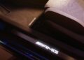 The car interior presents an illuminated AMG logo on the door sill, subtly highlighting the luxurious white seat, hallmark of the MANUFAKTUR Edition in this Limited-Edition Mercedes-AMG CLE.