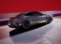 A sleek, dark-colored Mercedes-AMG sports car with yellow accents is shown against a red and purple abstract background, embodying the sophistication of the CLE MANUFAKTUR Edition.