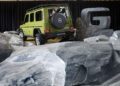 A green Mercedes-Benz G-Class SUV, part of the exclusive 1-of-460 series, is parked on artificial rocks indoors, with a large grey letter "G" display in the background. STRONGER THAN THE 1980s.