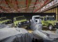 Three green Mercedes-Benz G-Class SUVs are displayed indoors on artificial rocks, showcasing the iconic STRONGER THAN THE 1980s design, with a large metallic "G" sculpture in the background.