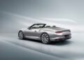 The silver convertible Bentley is showcased from the rear and side on a smooth, light background, highlighting the sleek design and open-top elegance of a Continental GT.