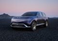 A sleek, dark blue SUV with a futuristic design stands as a testament to Genesis's vision for concept cars, parked on a gravel surface with mountains in the background under a twilight sky.