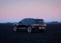 A dark-colored SUV from the Genesis Blank Canvas Campaign is parked on a flat, rocky terrain. The sky, a gradient of pink and purple hues, hints at sunset or sunrise. Mountains are faintly visible in the distance, offering an ideal backdrop for showcasing innovative concept cars.